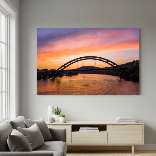 The “Austin Glow | Pennybacker Bridge Wall Art” hangs above a modern white sideboard on a light gray wall in a bright minimalist living room with a gray sofa.