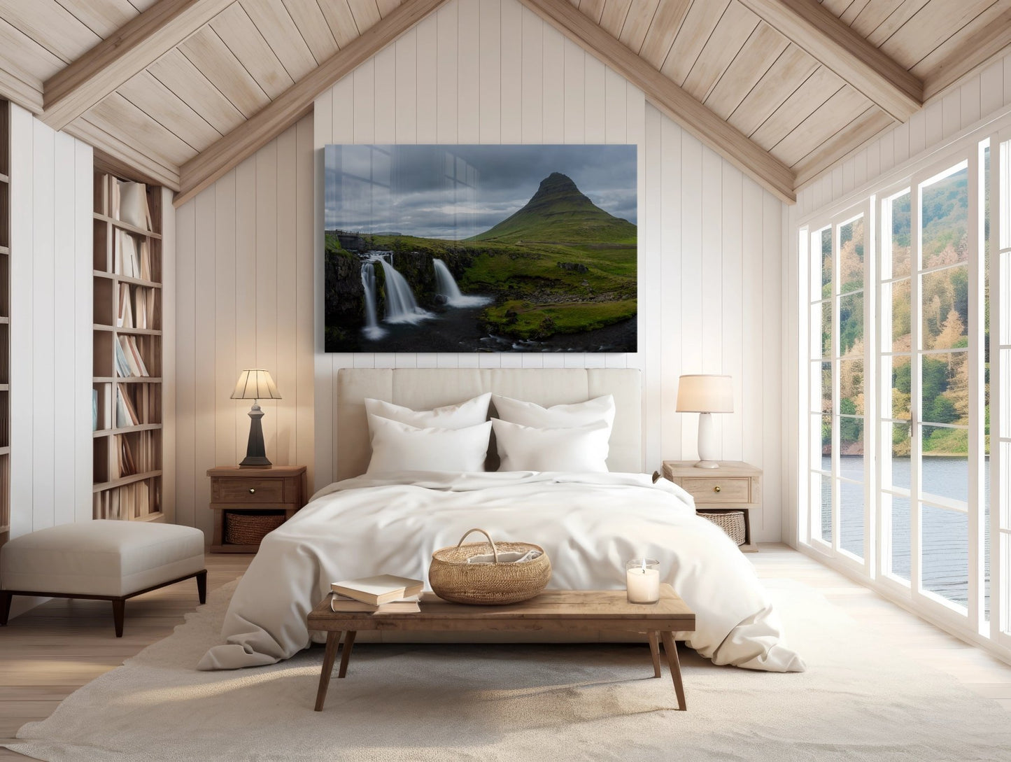 Cozy attic bedroom with a white bed, wooden furniture, bookshelves, lamps, and large windows. Above the bed hangs the Kirkjufell Iceland Photography Print - Three Waterfalls One Mountain, showcasing the iconic landscape.