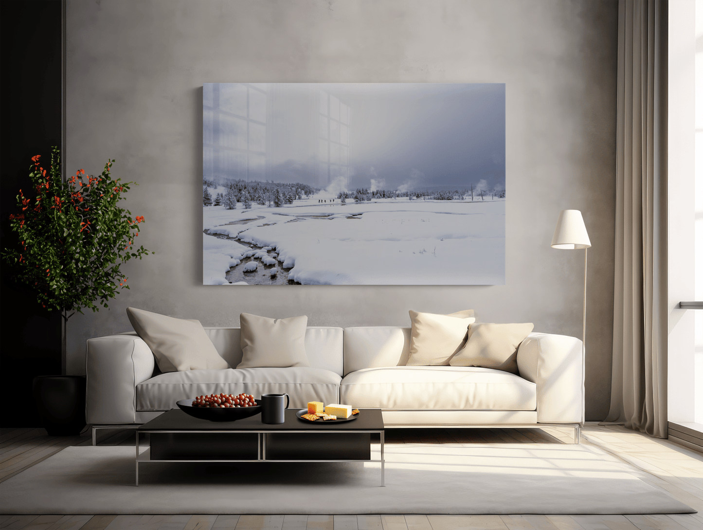 A modern living room with a white sofa, neutral pillows, a black coffee table, a floor lamp, and "Worth the Rest - Yellowstone Winter Photography Print" as nature wall art above the sofa. A leafy plant sits in the corner.