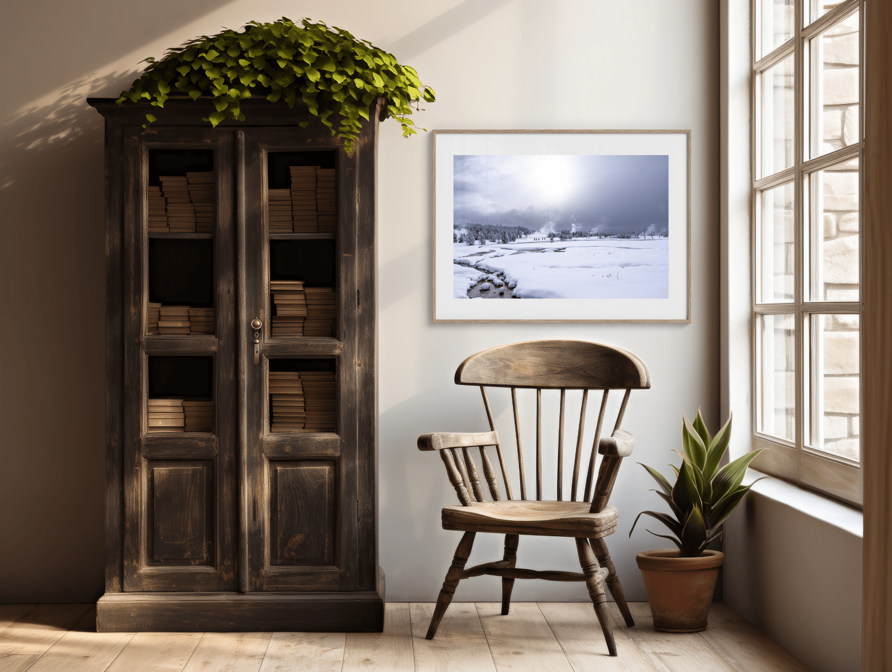 A cozy reading nook with a wooden chair, potted plant, vintage book-filled cabinet, and the "Worth the Rest - Yellowstone Winter Photography Print" as nature wall art beside a sunlit window.